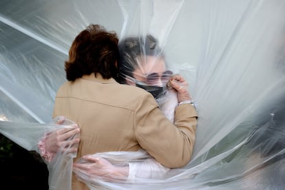 A woman hugs her grandmother through a plastic sheet in New York, in May 2020.