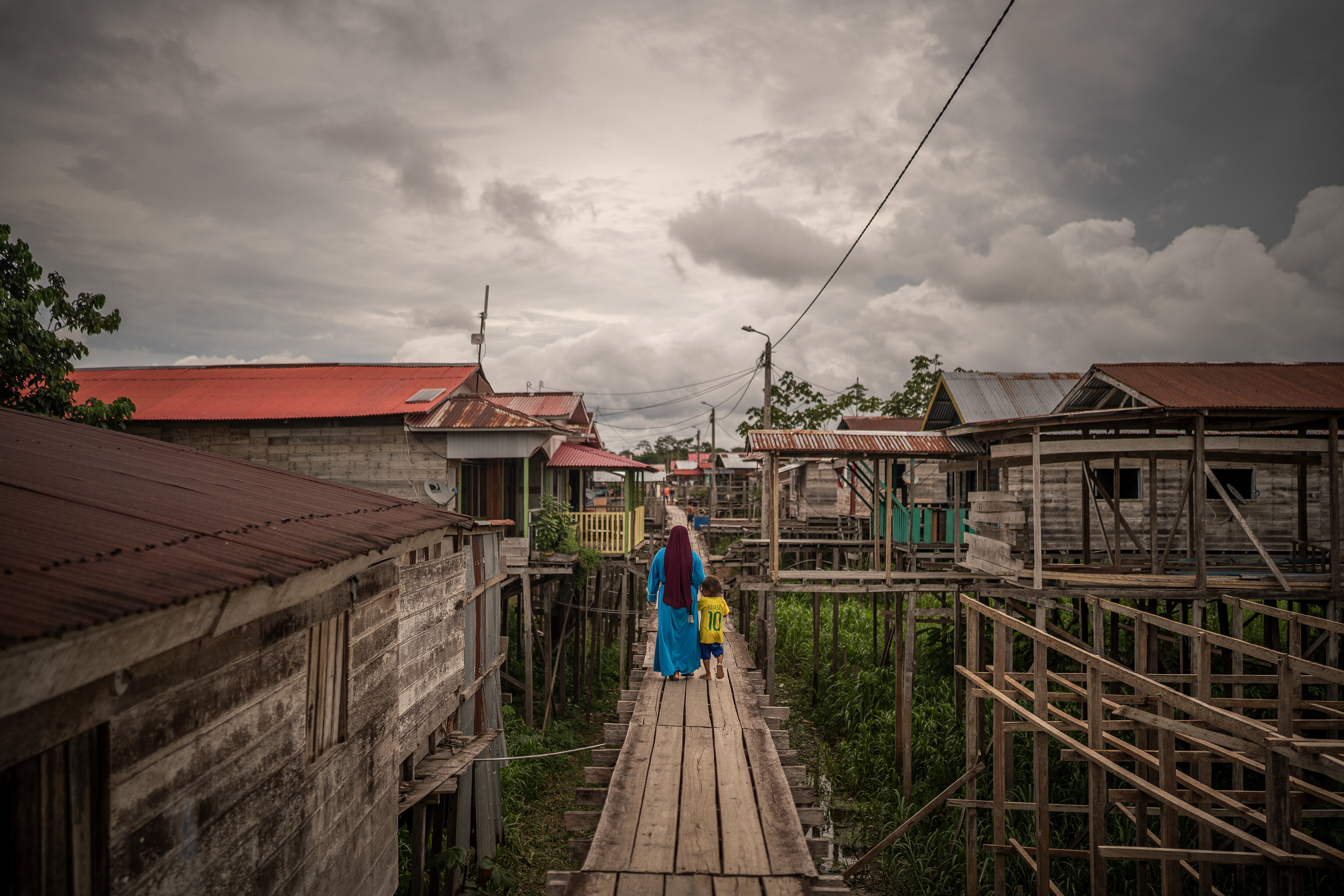 Una mujer camina con un niño en las calles del pueblo Islandia en el Amazonas peruano, el 12 de diciembre del 2024. 