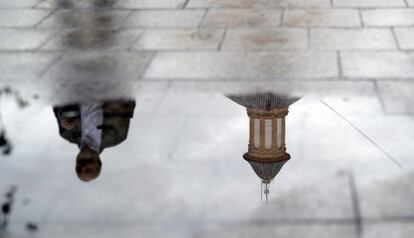 Un hombre reflejado en un charco de una calle de Valencia, el 27 de octubre.