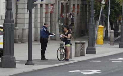 Un agente de la Policía Municipal de Madrid identifica a una ciclista fuera de horario en la Puerta del Sol.