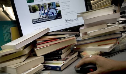 Una mesa llena de libros y un ordenador. 