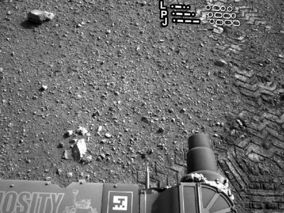 Las rodadas del robot ‘Curiosity’ en el suelo de Marte se aprecian en esta fotografía en la que destaca en primer plano el propio vehículo. 