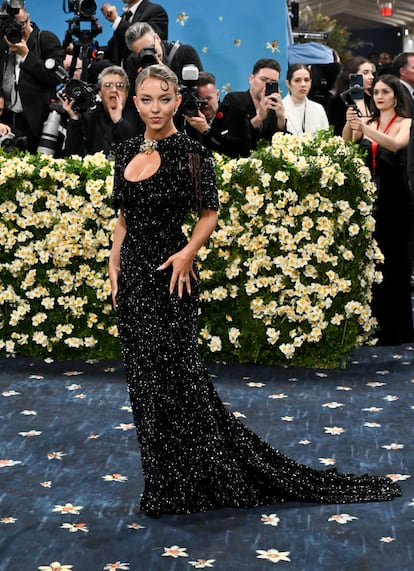 La actriz Sydney Sweeney ('Euphoria', 'Cualquiera menos tú), con traje negro de lentejuelas de estilo años cuarenta rematado con un broche en el escote. Está creado a medida en los talleres de Miu Miu, firma de la que Sweeney es imagen.