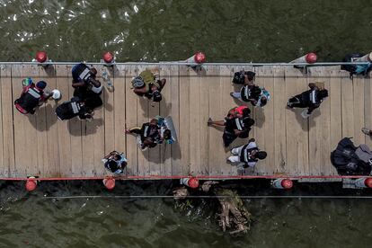 Migrantes en un muelle de Necoclí