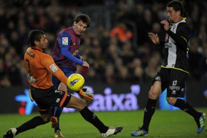Messi dispara ante Munúa con Del Horno observando la acción.