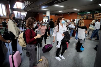 Viajeros en la estacin de Atocha poco antes de las 15.00. Muchos madrile?os tenan previsto viajar este puente antes de que el Gobierno declarara el estado de alarma, y por lo tanto las restricciones que limitan las salidas y entradas de poblacin a la capital.