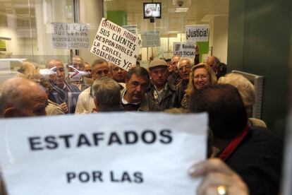 Un grupo de personas en el interior de la oficina de Bankia de la Gran Vía de Madrid donde se han encerrado.