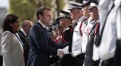 El presidente Macron, junto a la alcaldesa de París, Anne Hidalgo, saluda a policías en el homenaje a Xavier Jugele, agente muerto en un ataque el pasado año en los Campos Elíseos.