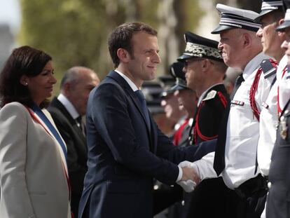 El presidente Macron, junto a la alcaldesa de París, Anne Hidalgo, saluda a policías en el homenaje a Xavier Jugele, agente muerto en un ataque el pasado año en los Campos Elíseos.