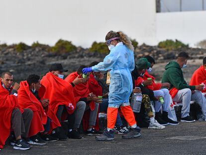 Un voluntario de la Cruz Roja atiende a un grupo de migrantes el pasado 7 de septiembre, en Las Caletas, Islas Canarias.