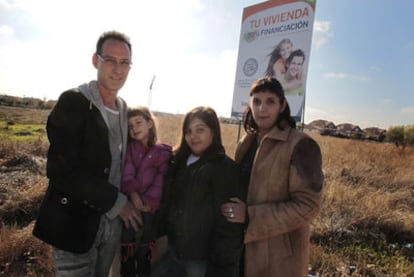 José Luis Blanco y Ruth Cuadrado, con sus dos hijas, junto al anuncio de una promoción inmobiliaria en Villanueva de la Torre.