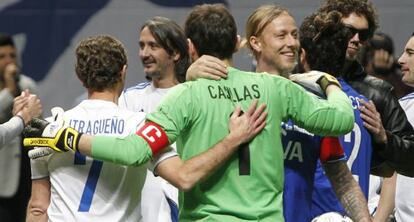 Casillas, abrazado ayer por Butragueño y Guti.