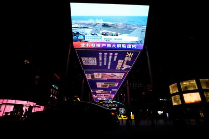 The evening news broadcast shows Chinese fighter jets on an aircraft carrier on April 10, 2023.