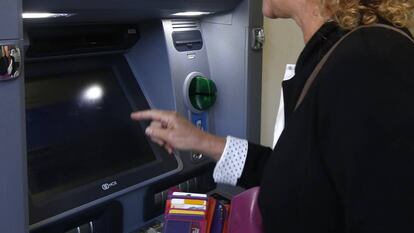 Una mujer retira dinero de un cajero automático, en Terrassa (Cataluña).