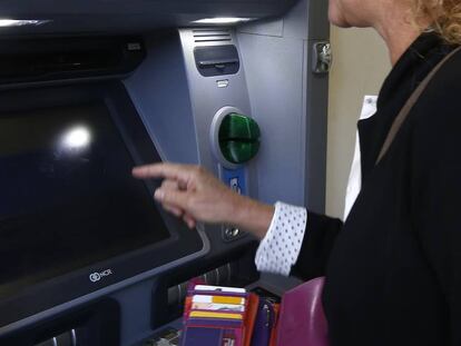 Una mujer retira dinero de un cajero automático, en Terrassa (Cataluña).