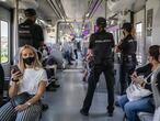 Varios agentes de controla el interior de un tren de Cercanías en las proximidades de la estación de Entrevías de Madrid. 
