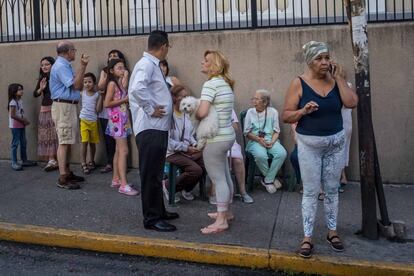 Un prolongado sismo, de magnitud 7,3 según el Servicio Geológico de Estados Unidos (USGS) y 6,3 de acuerdo con el instituto de sismología local, sacudió la tarde del martes a Venezuela causando pánico en la población, sin que hasta ahora se hayan reportado víctimas ni daños. En la imagen, un grupo de personas permanece en la calle después del temblor, en Caracas (Venezuela).