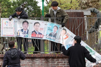 Retirada de carteles electorales, puestos para las elecciones legislativas de Corea del Sur, en Seúl, el 11 de abril.