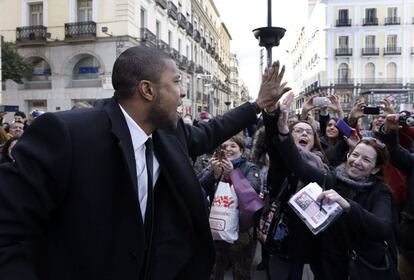 El jugador estadounidense del Real Madrid Marcus Slaughter saluda a varios aficionados en la Puerta del Sol, a su llegada a la Casa de Correos de Madrid.