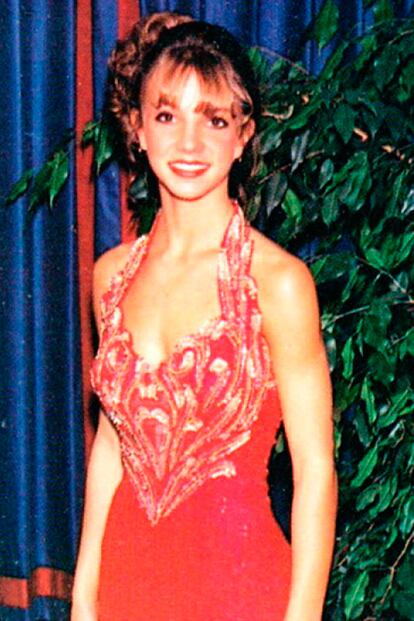 Si recordamos los estilismos noventeros de Britney Spears, poco nos puede sorprender su vestido de graduación. La cantante apostó todo al rojo y, a pesar de su juvenil rostro, se echó años encima con un moño muy poco favorecedor.