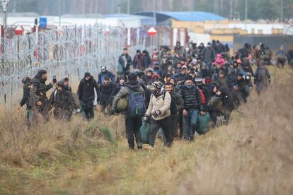 Un grupo de migrantes avanza a lo largo de la frontera de Bielorrusia con Polonia hacia un campamento para unirse a otros y tratar de entrar en Polonia, en la región de Grodno el 12 de noviembre de 2021. Cientos de migrantes desesperados continúan atrapados a temperaturas bajo cero en la frontera.