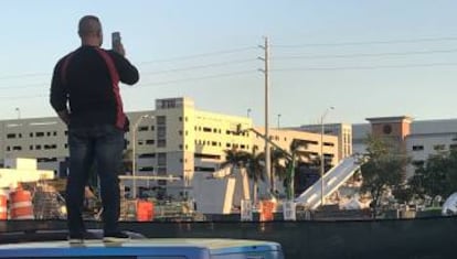 Un hombre toma una foto del puente derrumbado.