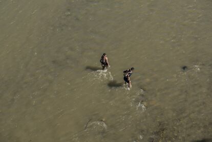 Dos padres se bañan con sus hijos pequeños en el río Huixtla.