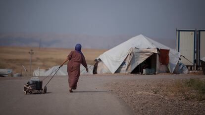 Una mujer siria transporta un cubo de agua en el campo de refugiados de Darashakran, en Erbil, Irak, en 2015.