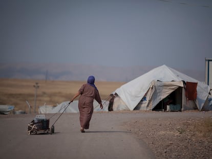 Una mujer siria transporta un cubo de agua en el campo de refugiados de Darashakran, en Erbil, Irak, en 2015.