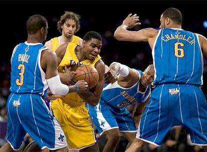 Andrew Bynum forcejea con varios defensores de los Hornets con Pau Gasol como testigo.