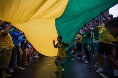 Un niño debajo de una bandera durante las protestas del 15.