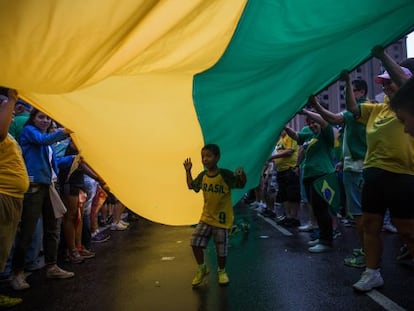 Un niño debajo de una bandera durante las protestas del 15.