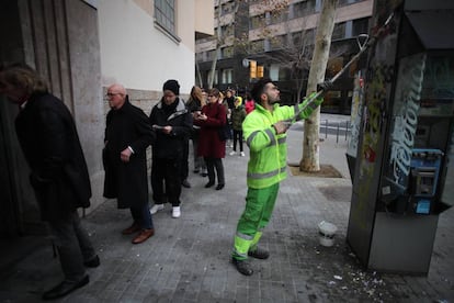 Un operario de limpieza borra una pintada al comienzo de la jornada electoral del 21-D, frente al Instituto Jaume Balmes, en Barcelona.