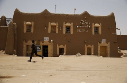Un hombre camina por delante de una pizzería en la ciudad de Agadez, al borde del desierto del Sáhara y una de las más pobres de Níger, que a su vez es el país más pobre del mundo.
