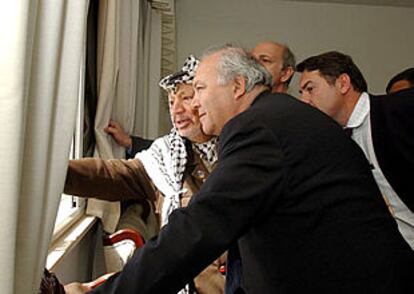 Arafat muestra al enviado especial de la UE, Miguel Ángel Moratinos, los daños del ataque a su residencia de Ramala.