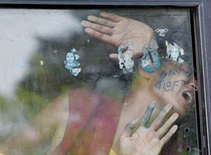 Un monje tibetano grita consignas contra China desde la ventana del furgón policial en el que lo transportan detenido, ayer en Nueva Delhi.