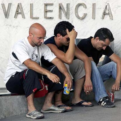 Familiares y amigos de las víctimas del accidente, sentados a la puerta del tanatorio de Valencia.