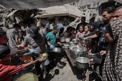 Varias personas recogen alimentos en un punto de entrega en Gaza este viernes.