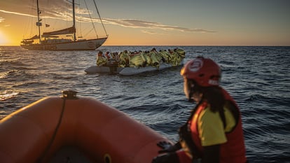 Trabajadores humanitarios mantienen guardia junto a un bote con 45 personas a bordo que han hallado a la deriva en el Mediterráneo.