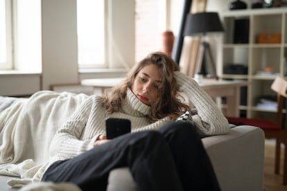 Una joven descansa en un sillón.