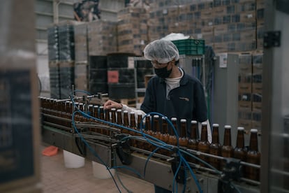 Un trabajador en la línea de producción de una cervecería en Zapopan.