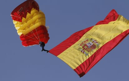 Despliegue de una bandera con motivo de la Fiesta Nacional.