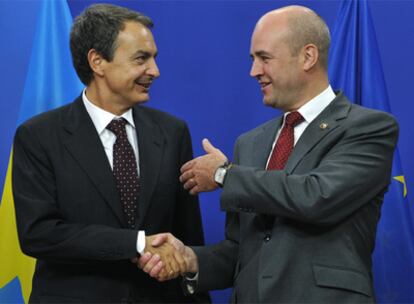 Zapatero saluda al primer ministro sueco y presidente de turno de la UE, Friedrik Reinfeldt, a su llegada a la reunión de Bruselas este jueves.