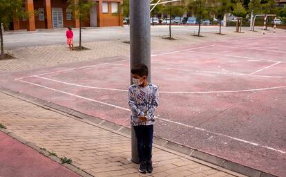 El niño Adrián Lezaun juega en el patio con su amiga Ainhoa Villanueva al fondo en el colegio Azpilagaña de Pamplona.