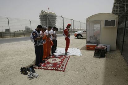 Varios trabajadores rezan en el circuito de Sakhir