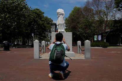 Un hombre toma una fotografía de una estatua de Colón a la que le fue arrancada la cabeza en Boston, en junio de 2020.