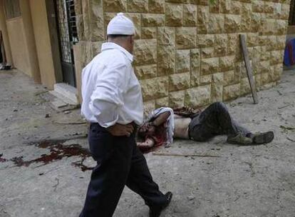 Un habitante de la aldea drusa de Shuwayfat pasa ante el cadáver de una víctima de los enfrentamientos entre facciones libanesas.