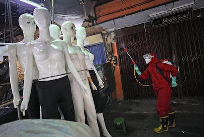 Un bombero rocía desinfectante en maniquíes como medida sanitaria contra el brote de coronavirus, en el mercado textil de Tanah Abang en Yakarta (Indonesia).