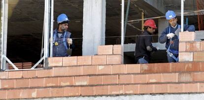 Tres obreros trabajan en la construcci&oacute;n de una vivienda. EFE/Archivo