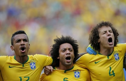 Luiz Gustavo, Marcelo Vieira e David Luis cantam o hino brasileiro com dedicação.